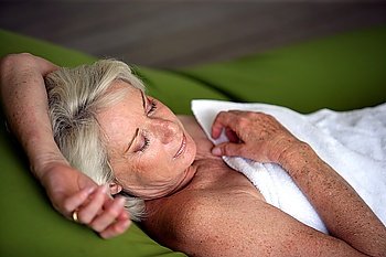 Senior woman asleep in a towel