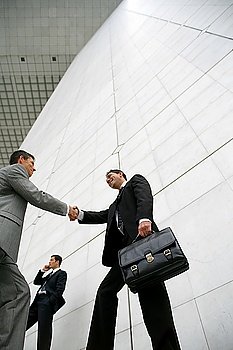 Businessmen handshaking, low-angle shot