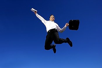Successful businessman jumping in the air
