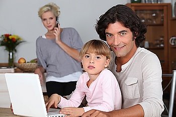 Family in kitchen with laptop