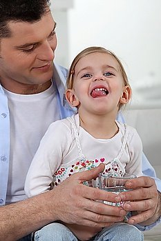 Father giving little girl drink of water