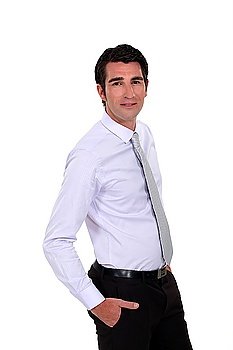 Confident young businessman stood with  hands in his pockets