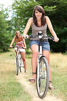 Two teenage girls on bikes