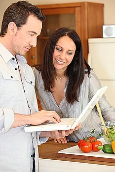 Couple using a laptop in the kitchen