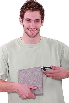 young man holding a tile and a nipper