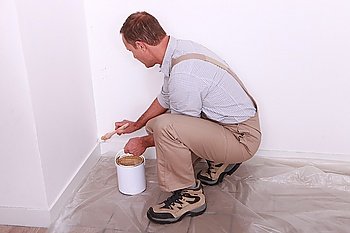 Painter painting baseboards