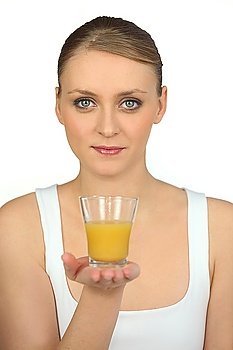 blonde woman showing a glass of orange juice