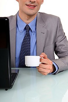 Businessman sat at laptop with morning coffee
