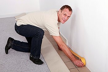 Man at home preparing to lay carpet