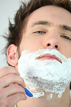 Man shaving using a disposable razor