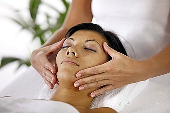 Masseuse giving face massage