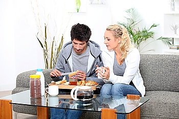 Couple having breakfast in their living room