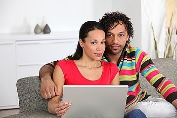 Mixed couple at home with laptop