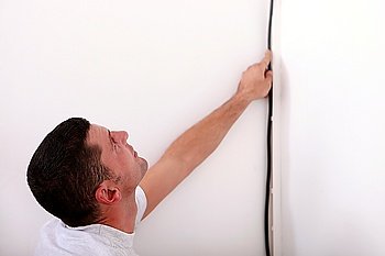 Electrician wiring a wall