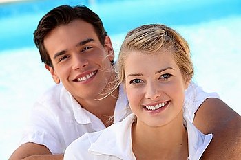 Smiling young couple with a blue sky background