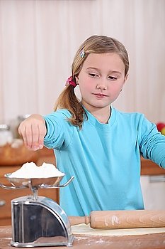 Child weighing flour on a scale
