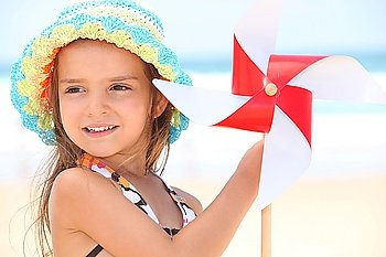 little girl at beach with toy windmill