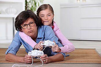Young girl playing a video game with her grandmother