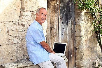 Senior man using a laptop with a blank screen