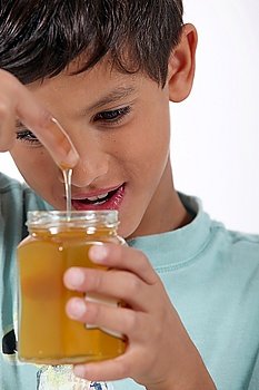 Little boy holding jar of honey