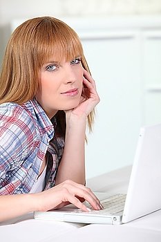 Causal redheaded woman using a white laptop computer