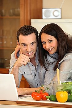 Couple in kitchen on laptop