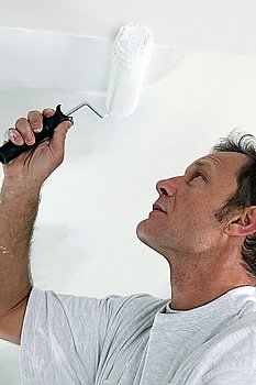 Decorator painting a room white