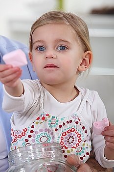 Little girl offering marshmallows
