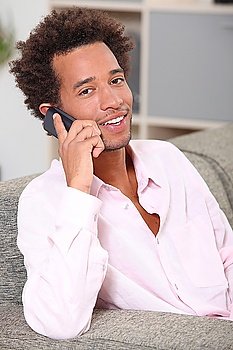 Young man making a call at home