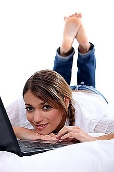 Woman looking at her laptop in bed