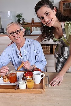 an old woman having breakfast with a younger woman