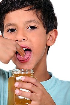 Boy tasting some honey