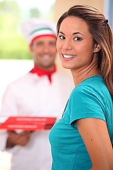 Delivery man bringing pizzas to young woman