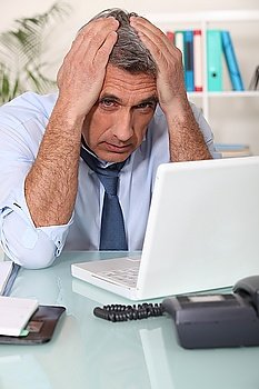 Stressed man using laptop