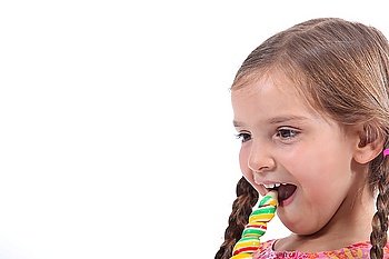 little girl eating a candy, looked amused and impish
