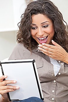 Beautiful young Latina Hispanic woman laughing, relaxing and using a tablet computer