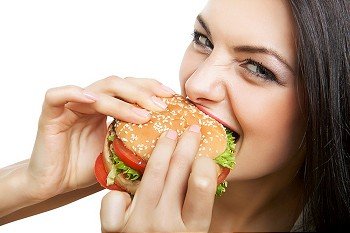 cute girl biting hamburger on white background