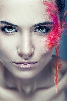 cute woman with flying coloured powder on face