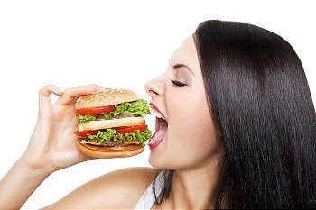 girl biting hamburger on white background