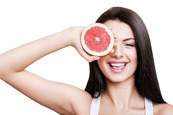 happy cute girl and grapefruit on white background