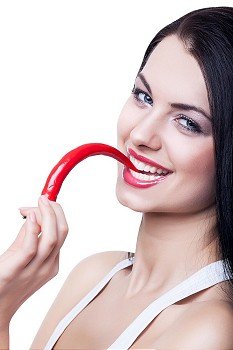 happy cute woman biting chili pepper on white background