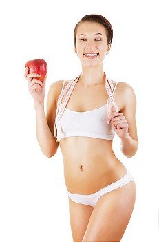 healthy attractive girl with tapemeasure and apple on white background