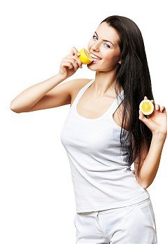 pretty smiling girl with two lemons on white background