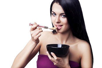 woman eating corn flakes on white background
