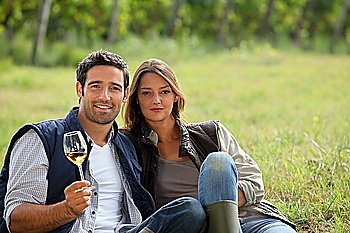 Couple having a glass of wine by a vineyard