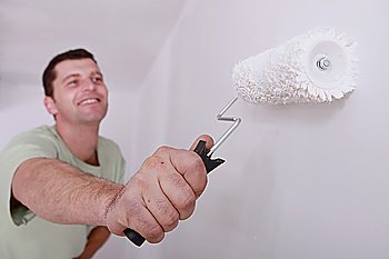 Man painting a room white