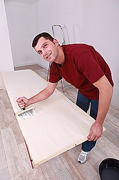 Man painting wooden plank