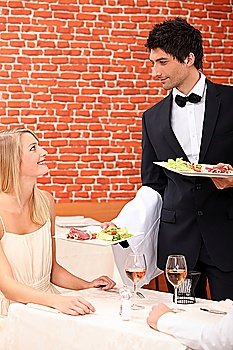 Waiter serving food to customer