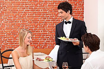 Waiter serving couple in restaurant
