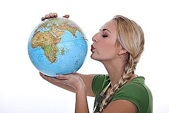 Woman in a green top kissing a globe